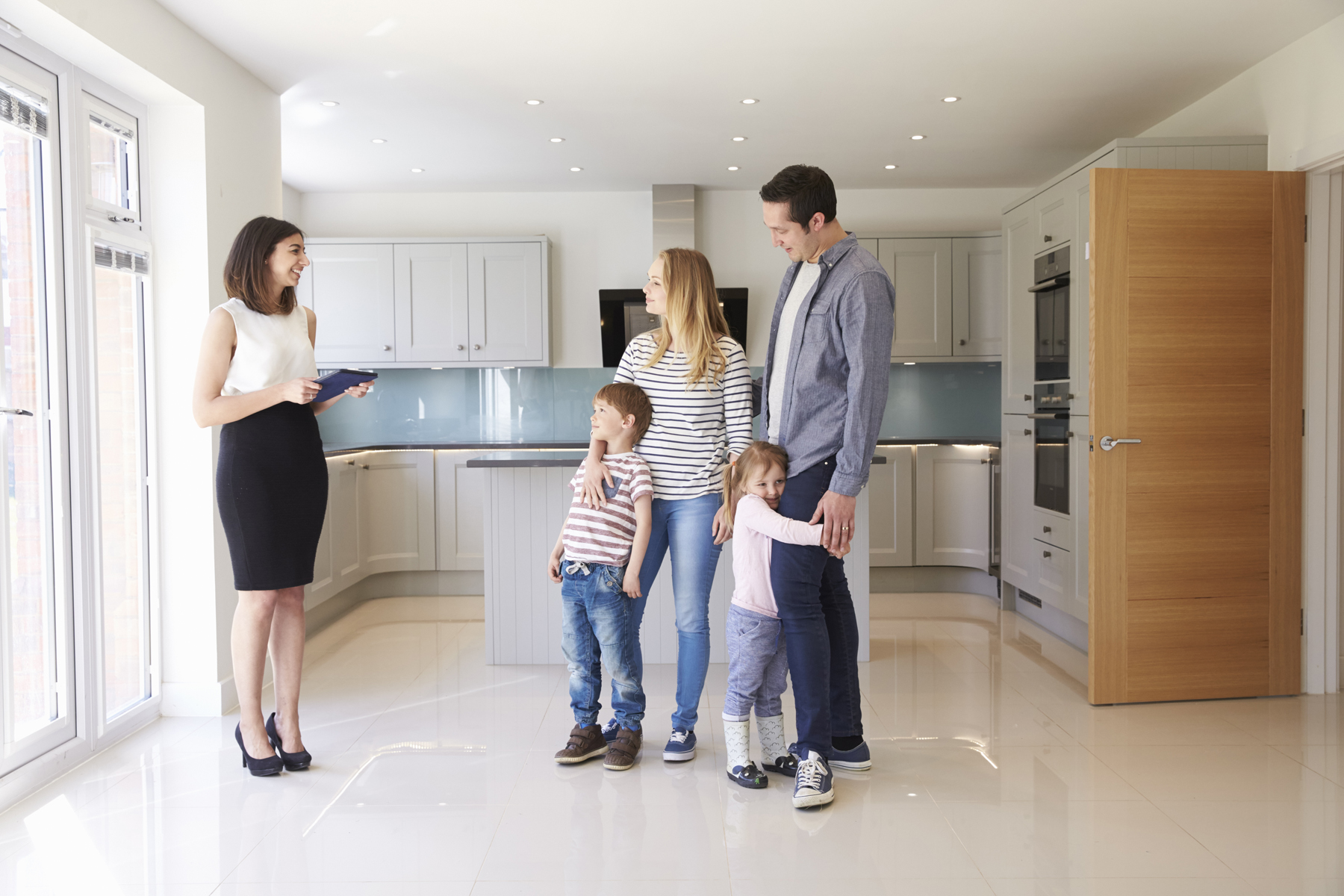 Realtor Showing Young Family Around Property For Sale